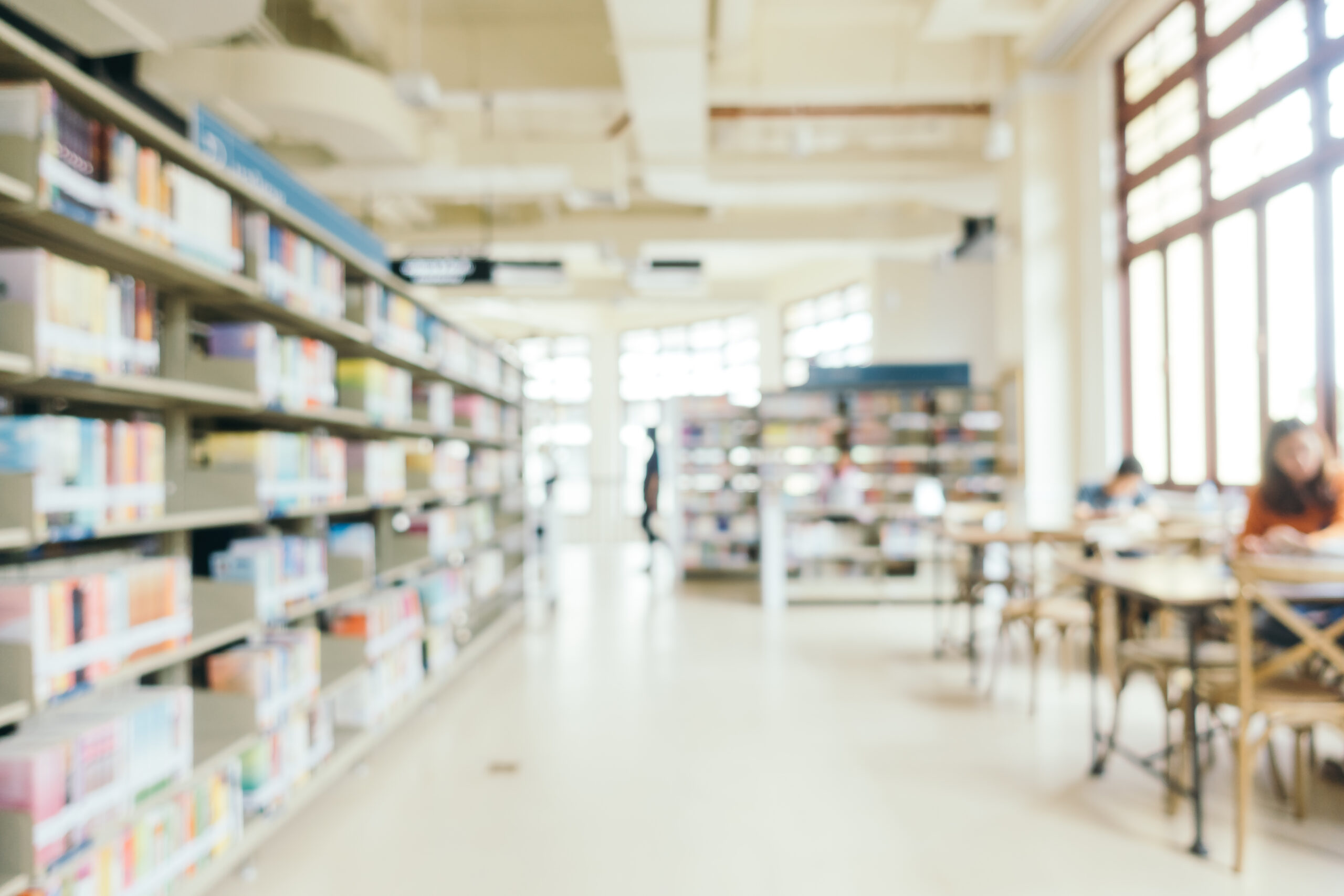 Abstract blur and defocused bookshelf in library interior for background